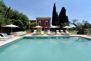 a large swimming pool with chairs and umbrellas at Agriturismo Santa Chiara in Alezio