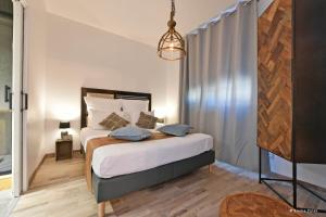 a bedroom with a large bed and a chandelier at Gîte Motobécane in Saint-Quentin +4 photos