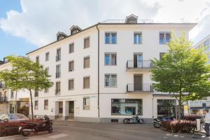 a white building with motorcycles parked in front of it at VISIONAPARTMENTS Cramerstrasse 2-6 - contactless check-in in Zürich