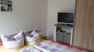 a bedroom with two pillows on a bed with a tv at Ferienquartier Müller T6 in Trassenheide