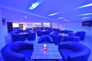a restaurant with blue chairs and a table and a room at SRM Hotel in Tuticorin