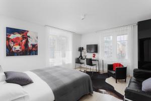 a white bedroom with a bed and a couch at VISIONAPARTMENTS Cramerstrasse 2-6 - contactless check-in in Zurich