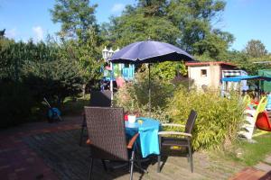 a blue table and chairs with an umbrella at Ferienquartier Müller T6 in Trassenheide