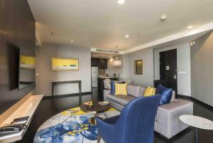 a living room with a couch and a table at Chatrium Hotel Riverside Bangkok in Bangkok
