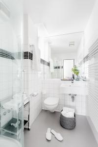 a white bathroom with a toilet and a sink at VISIONAPARTMENTS Cramerstrasse 2-6 - contactless check-in in Zurich