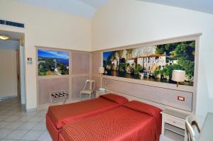 a bedroom with a red bed and a large painting on the wall at Hotel Moderno in Stresa