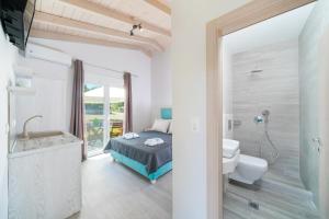 a bedroom with a bed and a toilet and a shower at Studios Periklis in Prinos