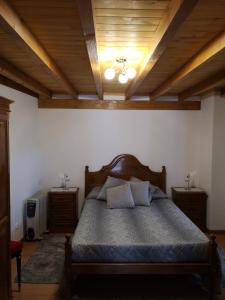 1 dormitorio con cama y techo de madera en CASA TITA, en Lavacolhos
