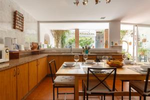 ヘレス・デ・ラ・フロンテーラにあるCasa La Albazanaのキッチン(木製テーブル、椅子、テーブルスターヤーヤーヤーヤーヤードレステリ付)