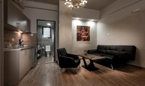 een woonkamer met een bank en een tafel en een keuken bij Pallada Athens boutique rooms & apartments in Athene