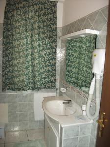 a bathroom with a sink and a phone at Hotel La Grotte in San Donato Val di Comino
