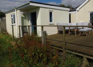 eine Terrasse mit weißen Stühlen und ein Haus in der Unterkunft Little Trenoweth in Saltash