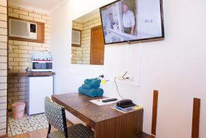 a kitchen with a table with a tv on the wall at Augusta Budget Motel in Port Augusta