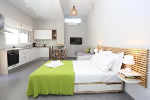 ein Schlafzimmer mit einem großen Bett, auf dem eine grüne Decke lag in der Unterkunft Polychrono Suite 2 in Polychrono