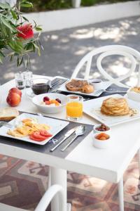 - une table blanche avec des aliments pour le petit-déjeuner dans l'établissement Racconto Boutique Design Hotel (Adults Only), à Parga