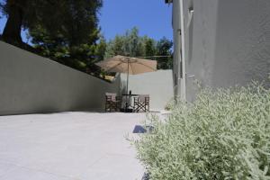 eine Terrasse mit Tisch und Sonnenschirm in der Unterkunft Polychrono Suite 2 in Polychrono