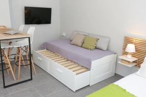 ein Bett in einem Zimmer mit Schreibtisch und Fernseher in der Unterkunft Polychrono Suite 2 in Polychrono