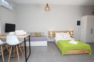 ein Schlafzimmer mit einem Bett und einem Schreibtisch mit Computer in der Unterkunft Polychrono Suite 2 in Polychrono
