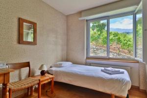 ein Schlafzimmer mit einem Bett und einem großen Fenster in der Unterkunft Maison familiale à Montreux avec vue sur le lac in Montreux