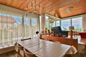 Maison familiale à Montreux avec vue sur le lac في مونترو: غرفة طعام مع طاولة وكراسي ونوافذ