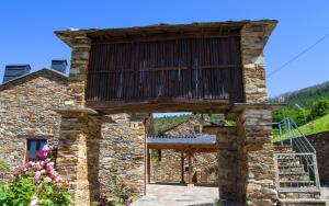 San Tirso de Abres的住宿－RURAL PRADO，一座石头建筑,上面设有一个阳台
