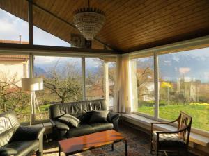 a living room with a couch and a table and windows at Maison familiale à Montreux avec vue sur le lac in Montreux