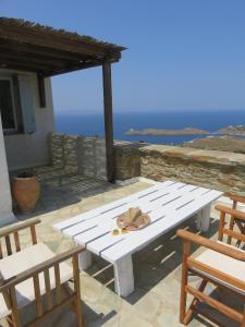a white picnic table sitting on a patio with chairs at Οντας της Αθηνάς in Gialiskari