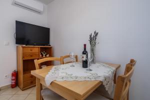 a dining room with a table with wine glasses and a television at Villa Milena in Trogir