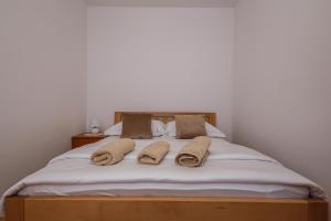 a bed with two pillows and towels on it at Villa Milena in Trogir