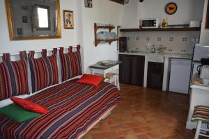 1 dormitorio con 1 cama con almohadas rojas y cocina en Apartamentos Carmen de Ramilla, en Granada