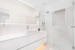 Un baño blanco con lavabo y ducha. en LXLUXHOME - Combro Luxury Apartment, en Lisboa 19 fotos más