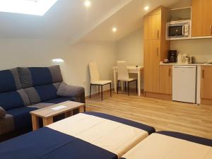 Una sala de estar con un sofá y una cocina. en Avenida De America Tijcal, en Madrid