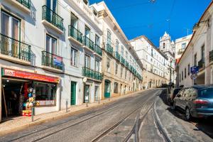 una calle vacía con edificios y un coche aparcado en la calle en WHome | Combro Luxury Apartment, en Lisboa