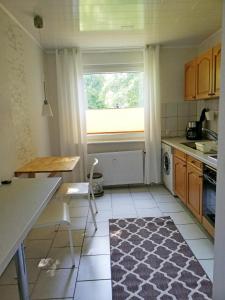 uma pequena cozinha com uma mesa e uma janela em Ferienwohnung Mammut 1 em Salzgitter