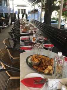 une longue table avec une assiette de nourriture dans l'établissement Roger's Hotel, à Ruse