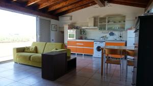 a kitchen and living room with a couch and a table at Masseria Donna Laura di Adriana Giangrande in Arnesano