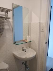 W łazience znajduje się umywalka i lustro. w obiekcie The Uptown Place Condominium w mieście Iloilo