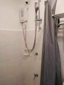 a bathroom with a shower with a shower curtain at The Uptown Place Condominium in Iloilo City