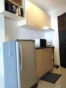eine Küche mit einem Kühlschrank und einer Mikrowelle in der Unterkunft The Uptown Place Condominium in Iloilo City