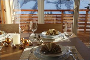 ein Tisch mit einer Kerze und Tellern und Weingläsern in der Unterkunft Haus Margaritta Top 4 in Damüls + 15 Fotos