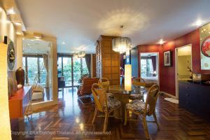 Rayong by Milanee في بان فيه: غرفة معيشة مع طاولة طعام وكراسي