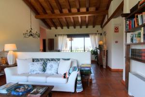 a living room with a white couch and a table at Hotel Llano Tineo in Villanueva de la Vera