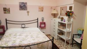 ポリニャーノ・ア・マーレにあるBed and Breakfast Dolce Sorrisoのベッドルーム1室(ベッド1台付)、壁にクロス付きのドレッサーが備わります。