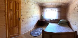 PilipetsにあるSadyba Domashniy zatyshokのベッドと窓が備わる小さな客室です。