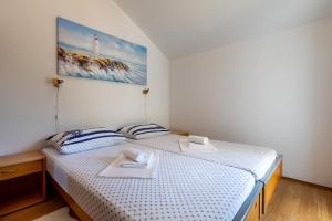 a bedroom with two twin beds with a picture on the wall at Apartment Relax Ston in Ston