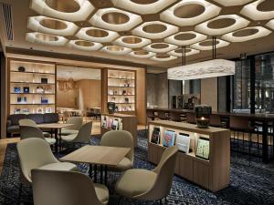 a lobby with tables and chairs and a library at Hotel Vischio Kyoto by GRANVIA in Kyoto