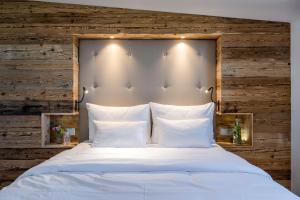 a bedroom with a white bed with a wooden wall at Chiemsee Chalet in Frasdorf +60 photos