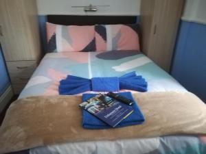 a bed with blue bows and a book on it at Delamere Hotel in Blackpool