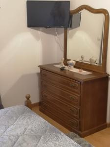 Dormitorio con tocador con espejo y cama en CASA TITA, en Lavacolhos