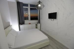 a white bedroom with a bed and a window at Central Panoramic Suite Rimini in Rimini